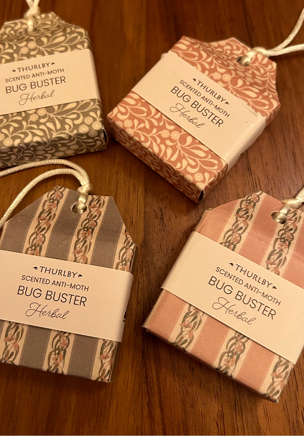 Four Thurlby Scented Anti-Moth Bug Buster Herbal packages on a wooden surface.