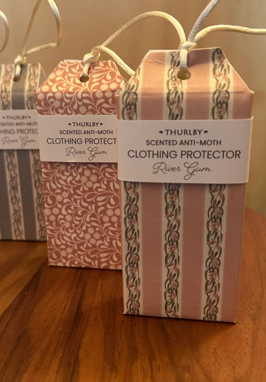Three boxes of Thurlby scented anti-moth clothing protector on a wooden surface.