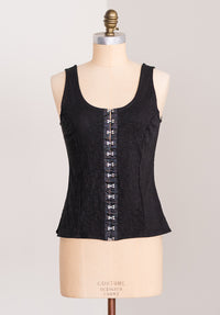 Black corset top on a mannequin with a plain background