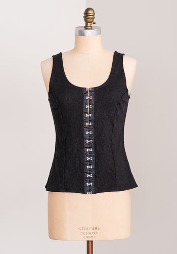 Black corset top on a mannequin with a plain background