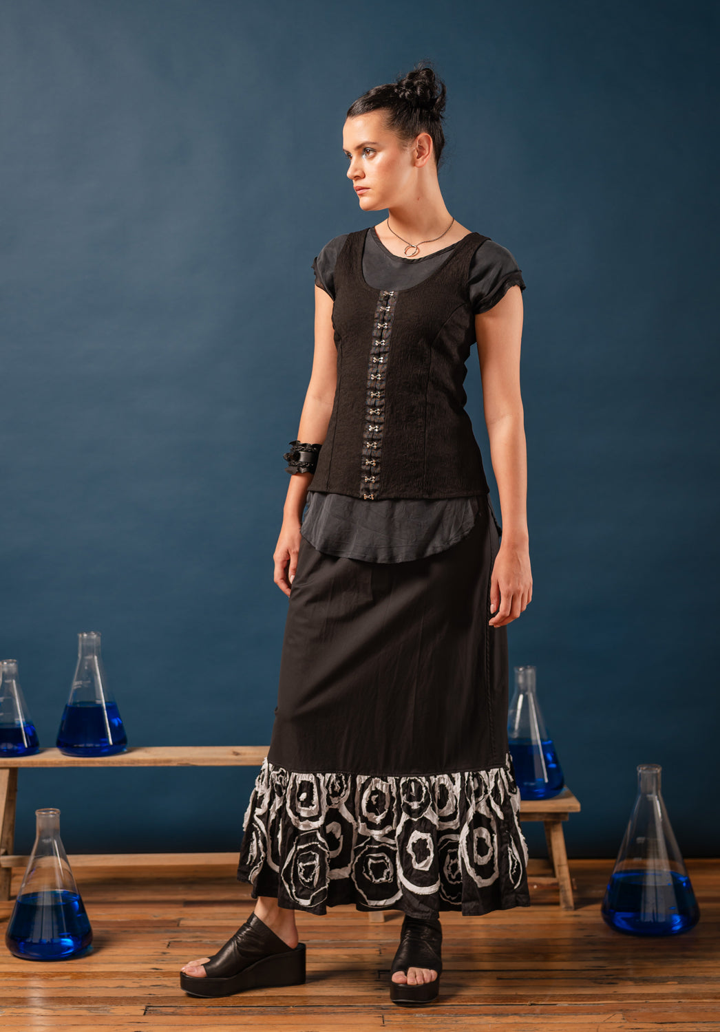 Black corset top on a mannequin with a plain background