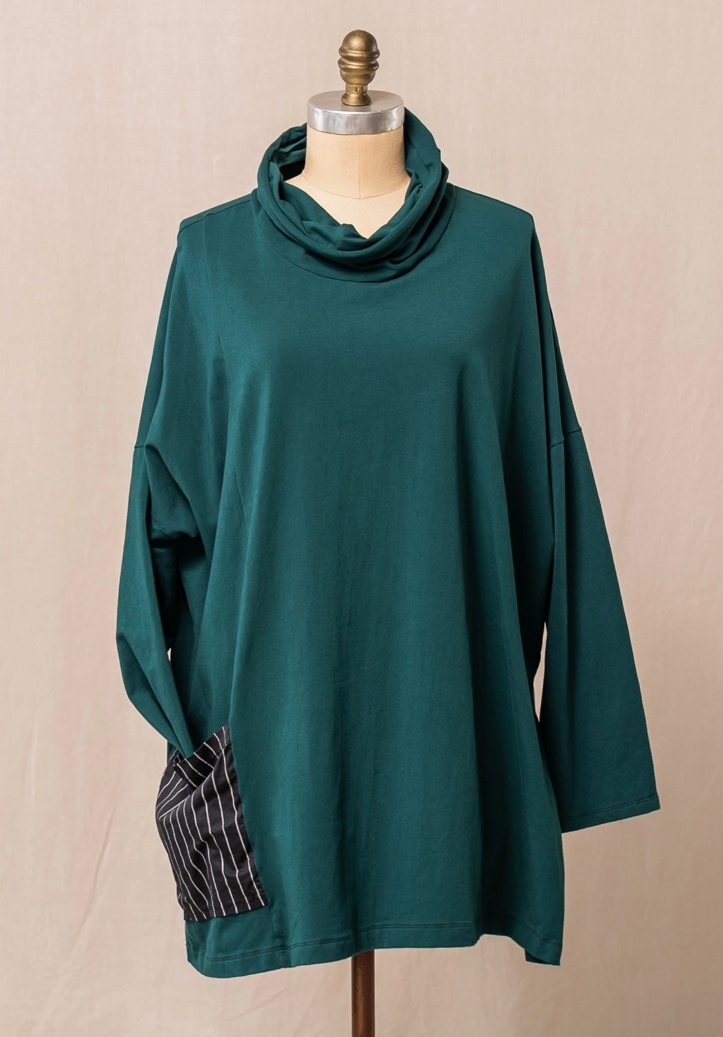 Teal cowl-neck cotton top on a mannequin against a beige background
