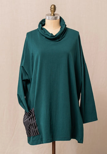 Teal cowl-neck cotton top on a mannequin against a beige background