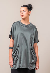 Woman wearing a loose-fitting green supima cotton t-shirt against a plain background