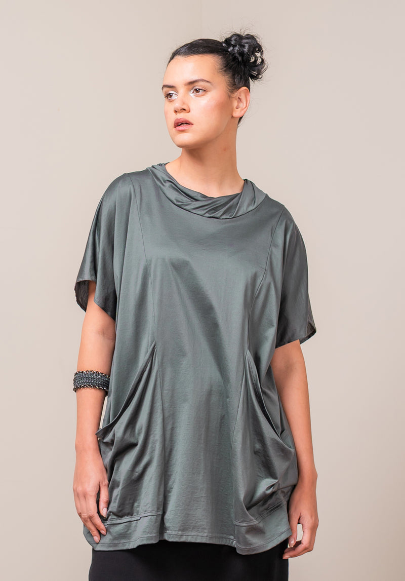 Woman wearing a loose-fitting green supima cotton t-shirt against a plain background
