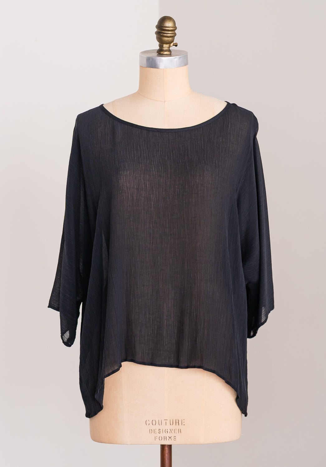 Black Japanese cupro sheer blouse on a mannequin with a plain background