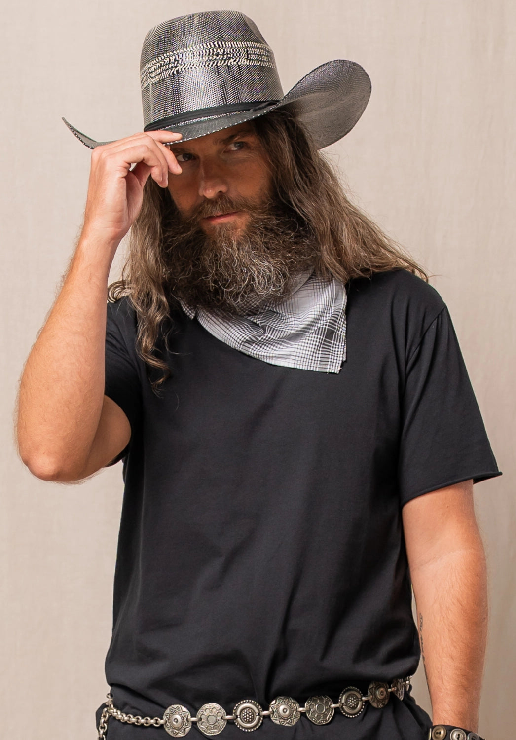 Man wearing a black t-shirt, gray hat, and patterned bandana against a beige background
