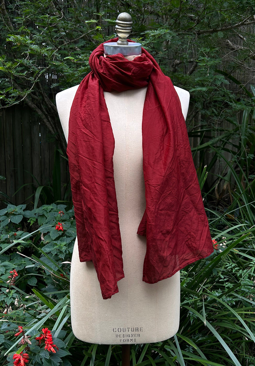 Red scarf on a mannequin against a natural background