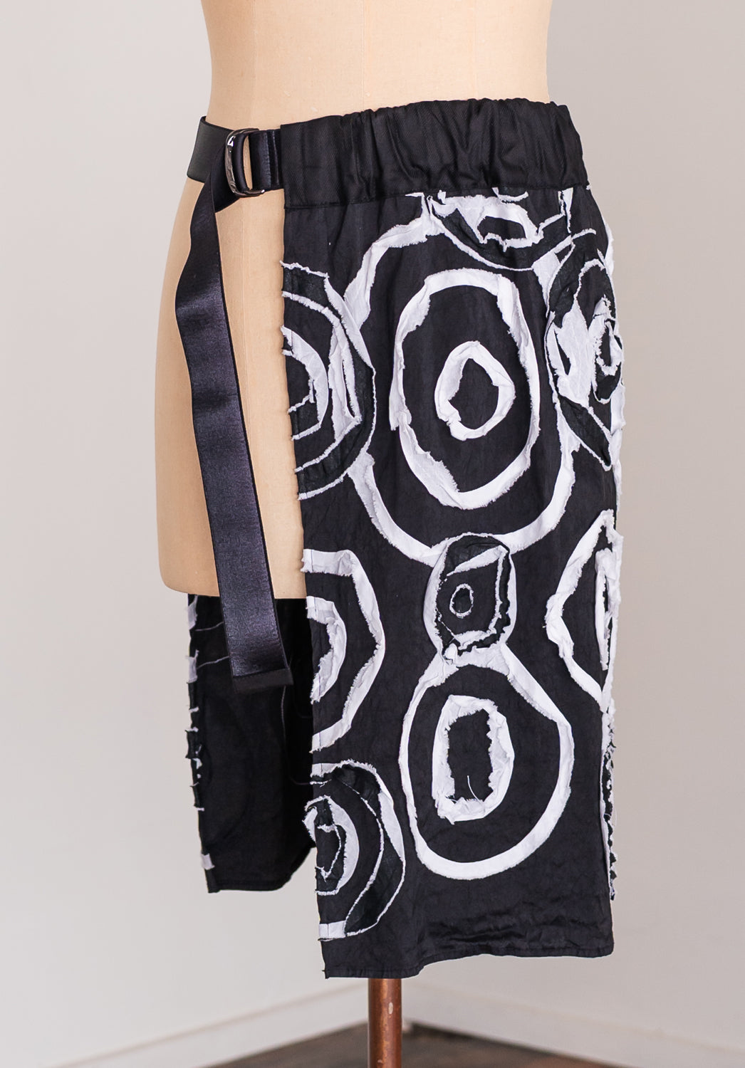 Black and white patterned skirt with a belt on a mannequin against a plain background